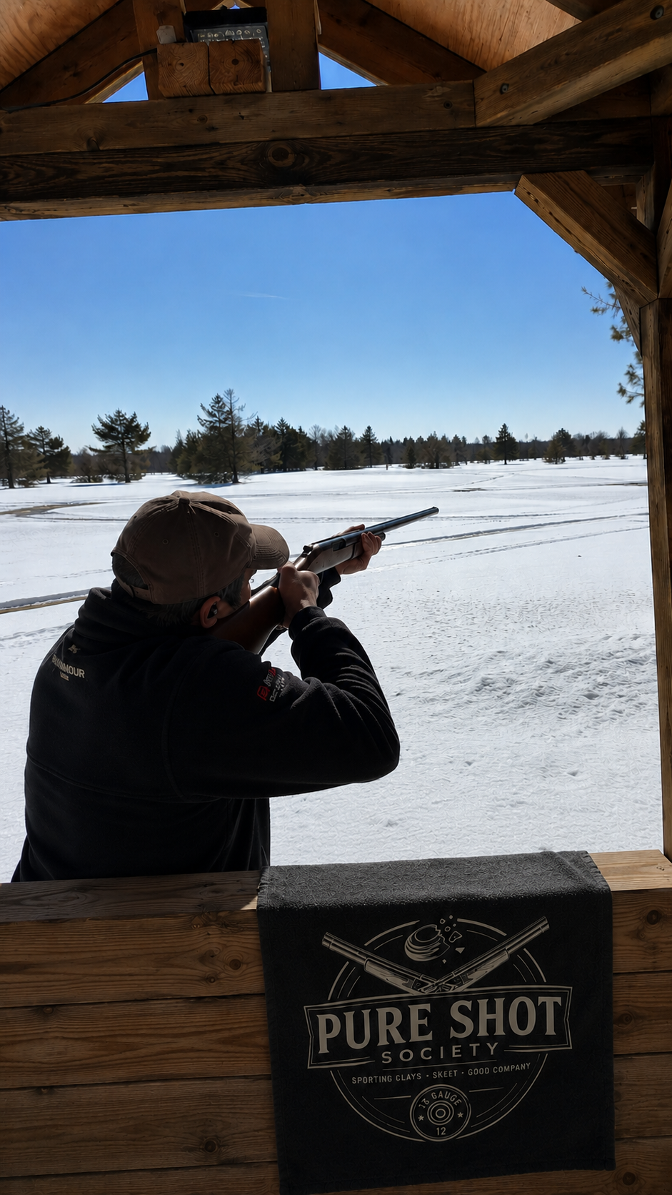 Shooter at a snowy range station with a Pure Shot Society towel